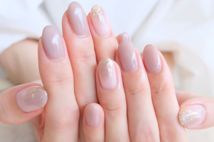 ピンクベージュのカラーにラメが塗られているジェルネイル画像