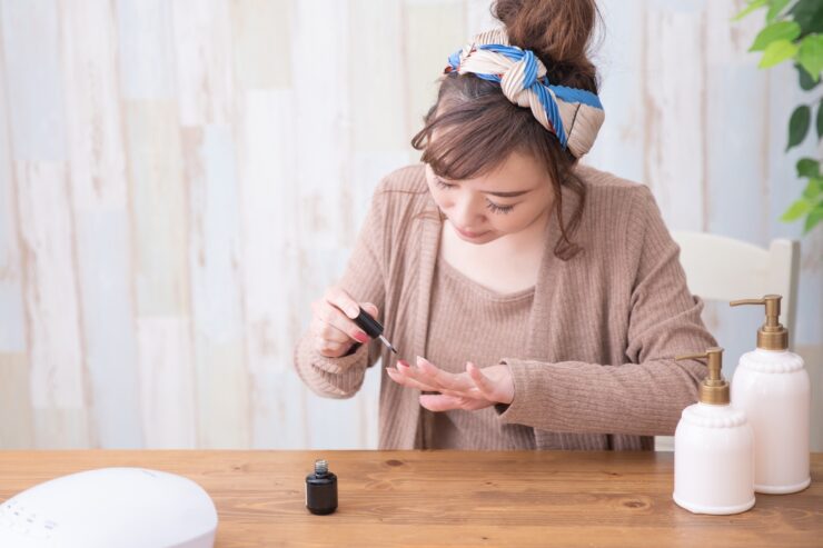 セルフネイルでトップジェルを塗っている女性の様子