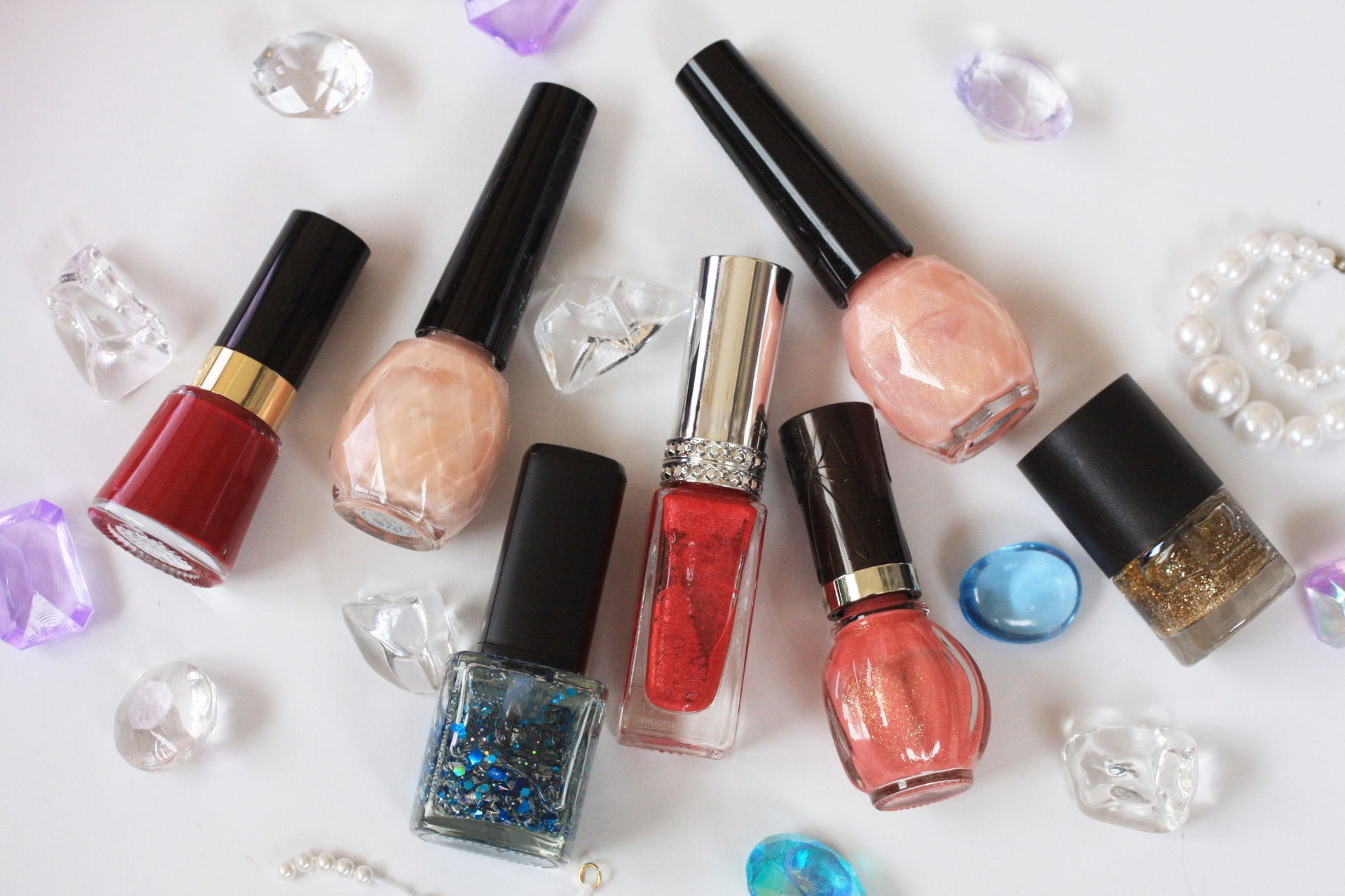 赤色やラメのマニキュアボトルが並んでいる画像