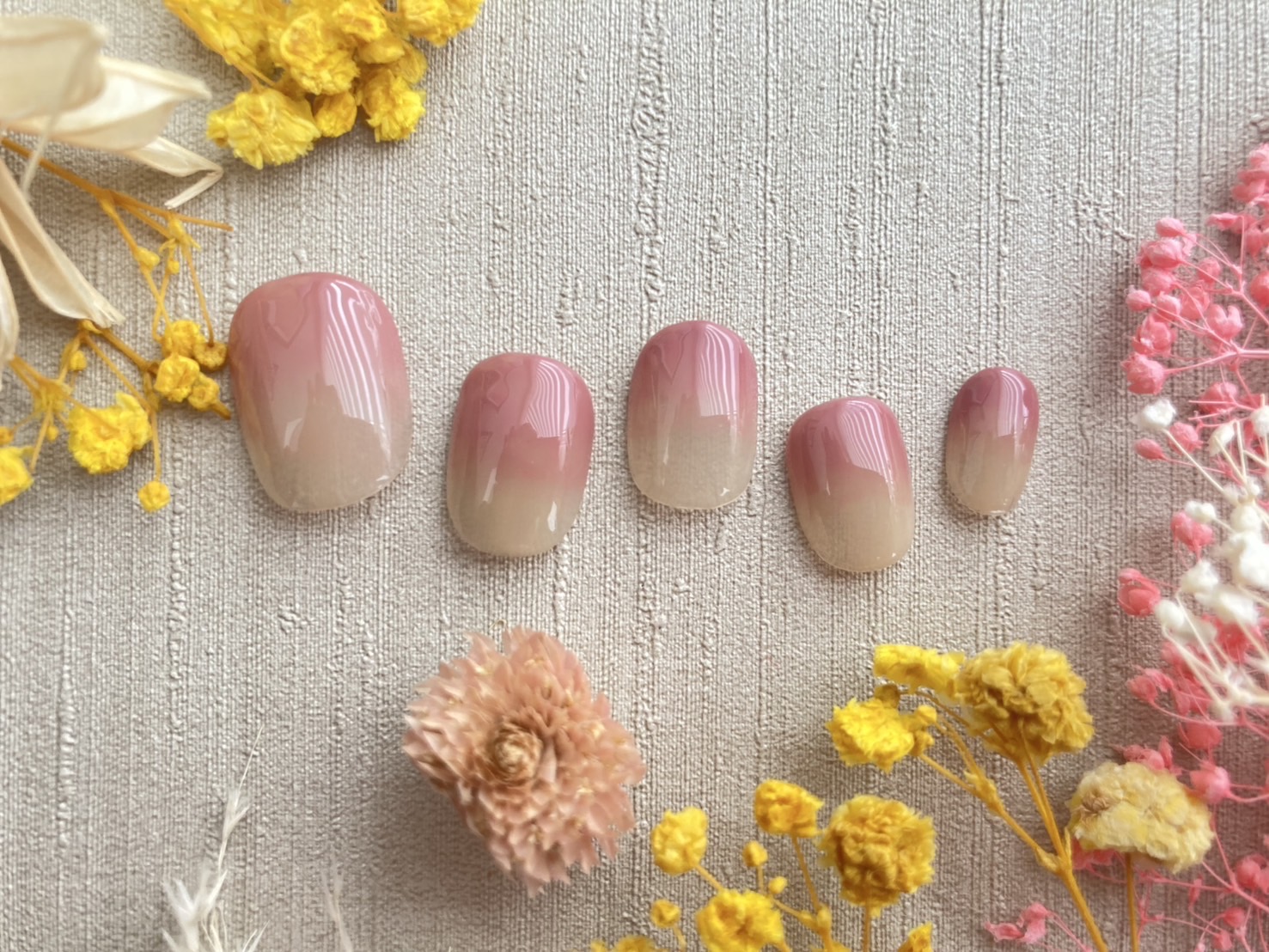 ピンク色のグラデーションネイルがデザインされたフット用のネイルチップ