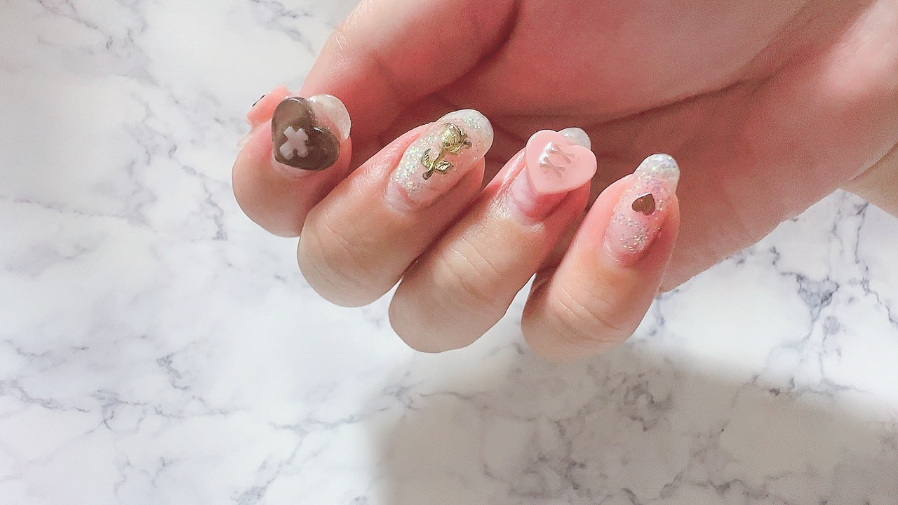 ハートの3Dネイルがデザインされた手元