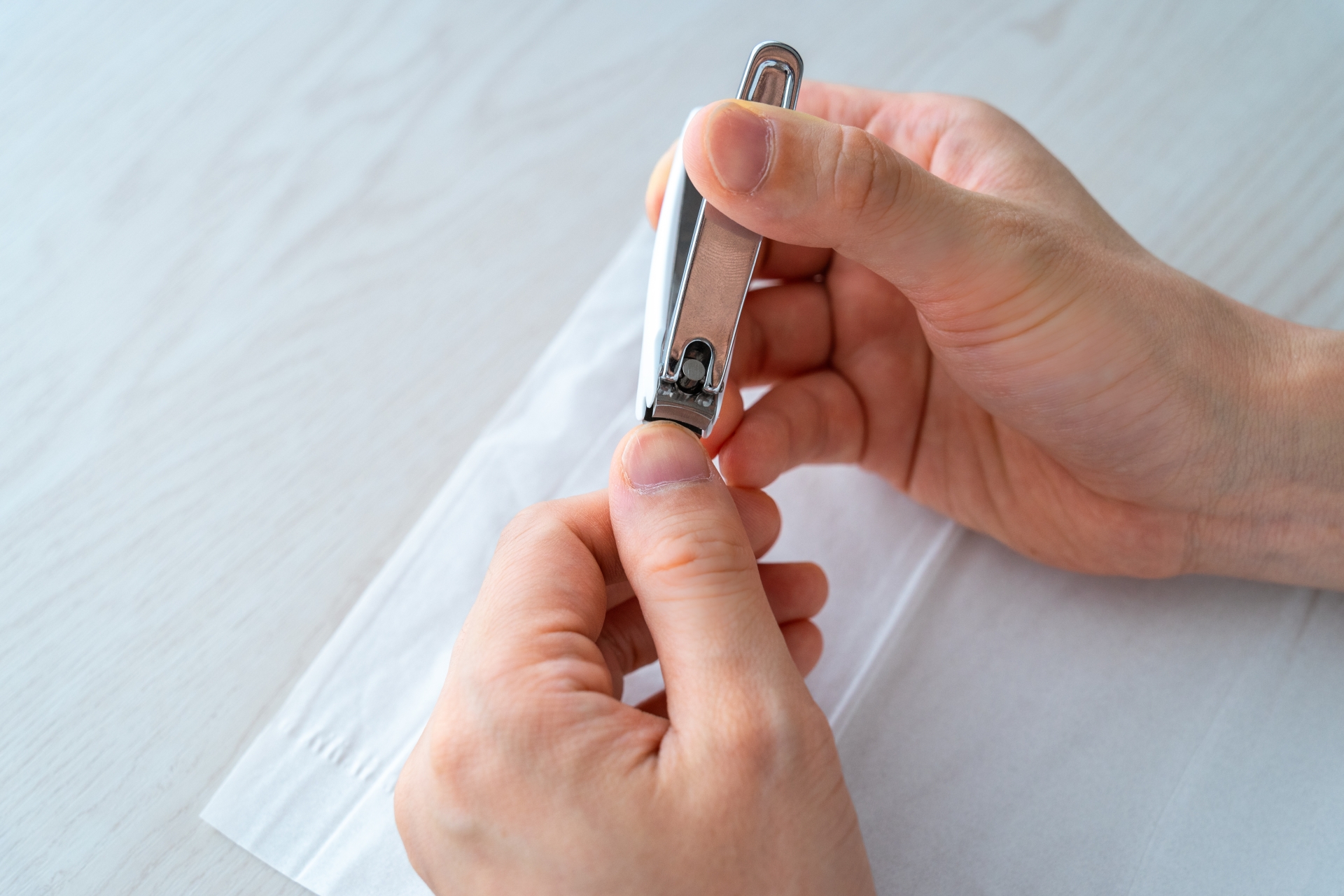 爪切りで爪を深く切っている画像