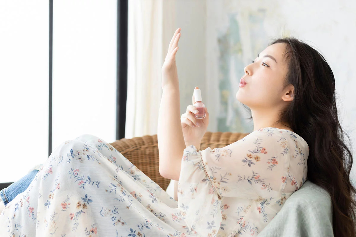椅子に座ってセルフネイルをしている女性