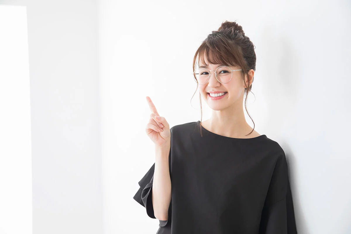 人差し指をあげてポイントを表現している女性