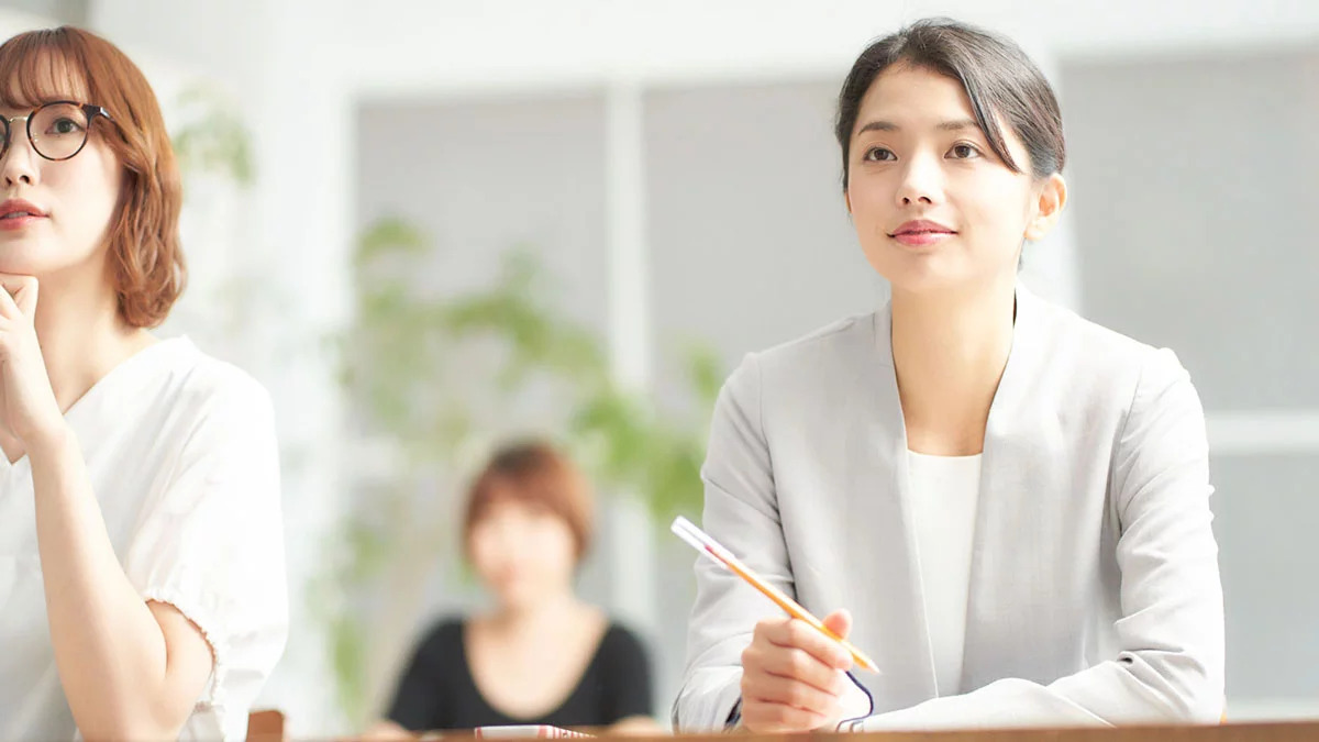 ペンを持ち真剣に授業を受ける女性