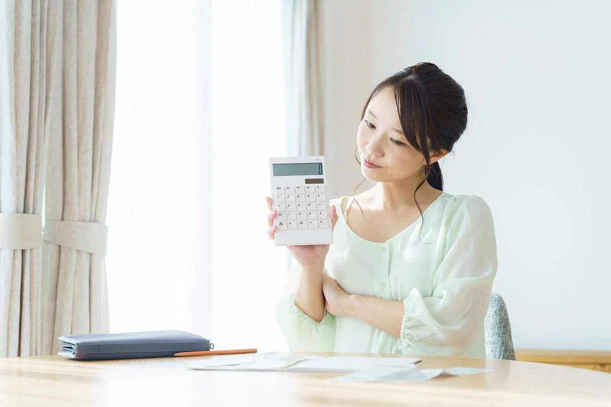電卓を持ち悩んでいる様子の女性